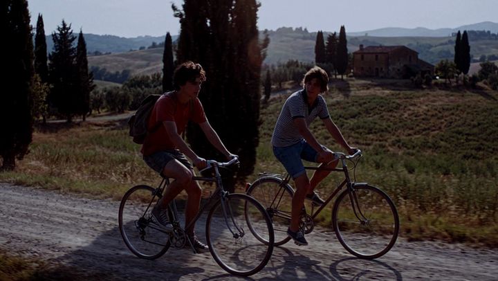 The same shot of two cyclists, graded by AI Color Match to the Emerald Obsession look
