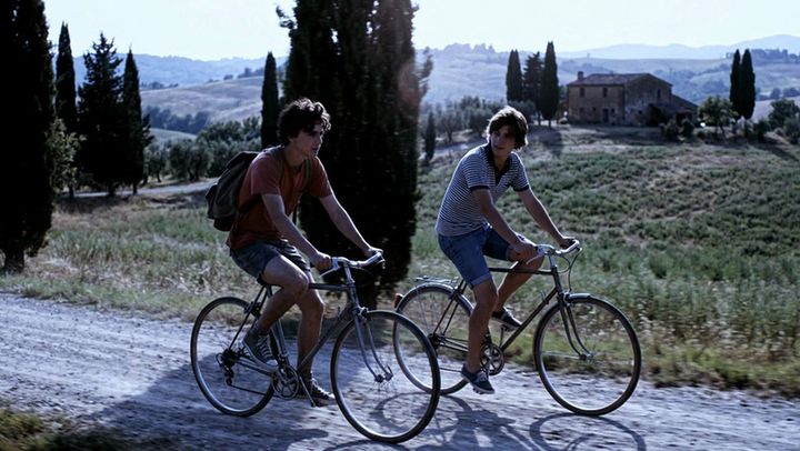 The same shot of two cyclists, graded by AI Color Match to the Favela Sun look