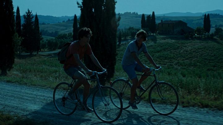 The same shot of two cyclists, graded by AI Color Match to the Replicant Rain look